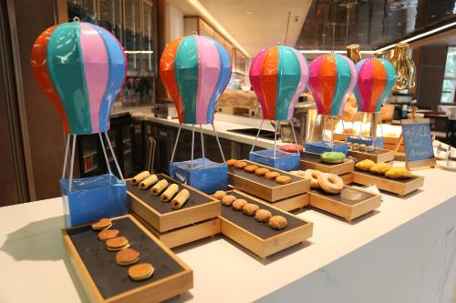 uma mesa com caixas de donuts e balões de ar quente em Marco Polo Jin Jiang em Jinjiang