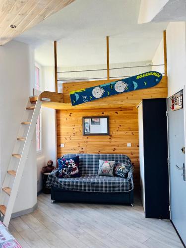 Cette chambre dispose d'un lit en mezzanine et d'un canapé. dans l'établissement Studio Endroit chaleureux au cœur des montagnes, à Argelès-Gazost