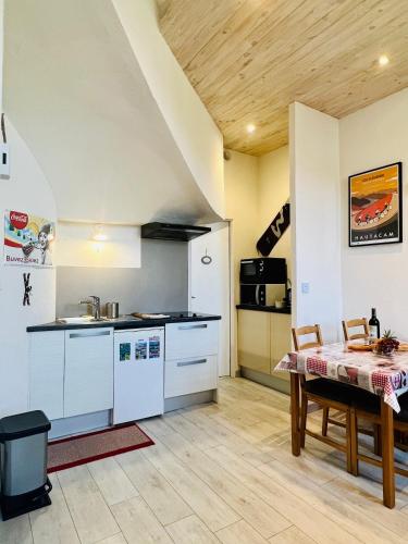 une cuisine et une salle à manger avec une table et un comptoir dans l'établissement Studio Endroit chaleureux au cœur des montagnes, à Argelès-Gazost