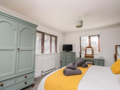 een slaapkamer met een groot bed en een gele deken bij Mill End in Penrith