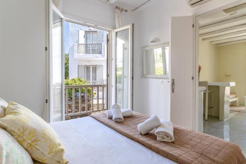 キオニアにあるNinemia Suites Tinos Grand 105のタオルが敷かれた大きなベッドのある寝室