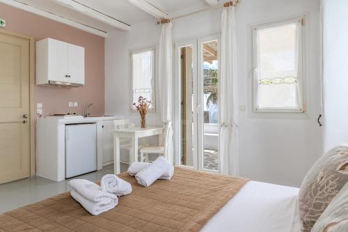 een slaapkamer met een bed en handdoeken op de vloer bij Ninemia Suites Tinos Superior 201 in Kionia