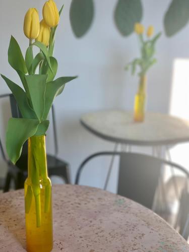 a yellow vase with yellow flowers in it on a table at HABITARE Lecce & Salento in Lecce