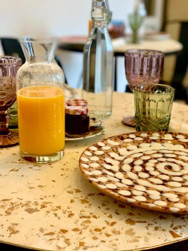 a table with a plate of food and a glass of orange juice at HABITARE Lecce & Salento in Lecce