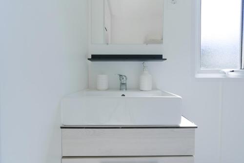 a white kitchen with a sink and a window at Mobile-home 132 in Lattes