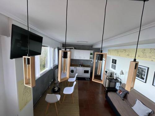a living room with a couch and chairs and a tv at Ibinaga Seaview - Auto checking property in Ibarrangelu