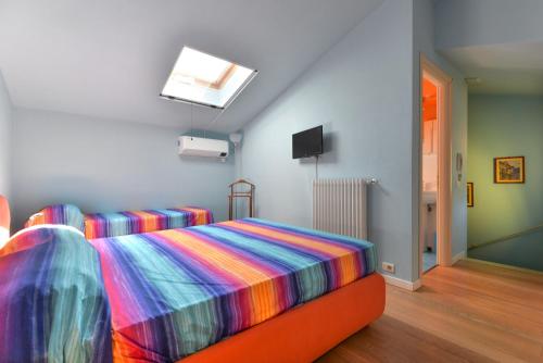 um quarto com uma cama com um cobertor colorido em Casa Minnie em Cavo