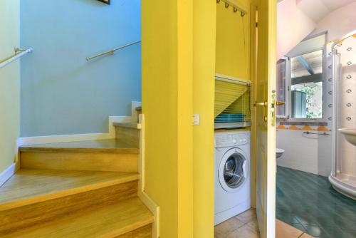uma lavandaria com paredes amarelas e uma máquina de lavar e secar roupa em Casa Minnie em Cavo