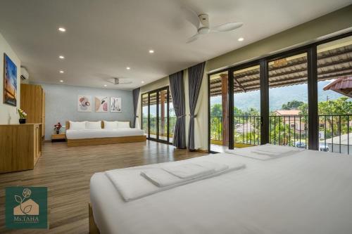 a bedroom with two beds and a balcony at Ms Taha Villas Ba Vi - Venuestay in Ba Vì