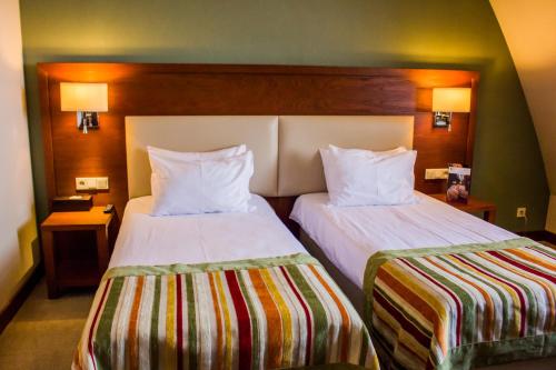 a hotel room with two beds and two lamps at Młyn Jacka Hotel & Spa in Wadowice