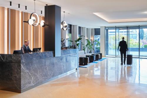 a lobby with two people sitting at a reception desk at Maistra City Vibes Hotel International in Zagreb