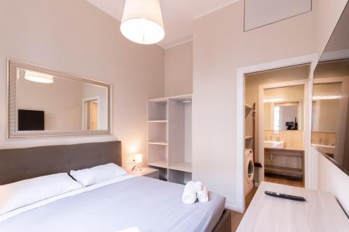 米兰Missori Apartment 1的卧室里有一张白色的床和一面镜子