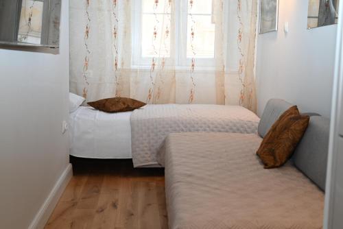 a small room with two beds and a window at Old Town Apartment in Omiš