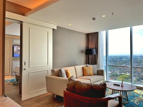 a living room with a couch and a table at Swiss-Belhotel Solo in Solo