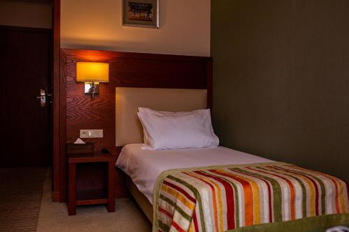 a hotel room with a bed and a nightstand with a bed sidx sidx sidx at Młyn Jacka Hotel & Spa in Wadowice