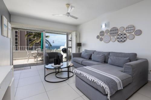 un soggiorno con divano e tavolo di 202 Ben Siesta - by Stay in Umhlanga a Durban