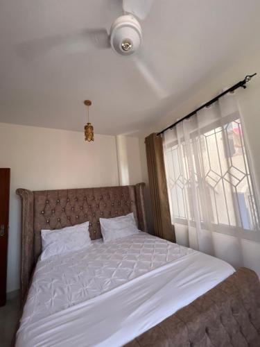 um quarto com uma cama branca e uma janela em Fully furnished one bedroom apartment in Mombasa VOK off nyali road em Mombasa