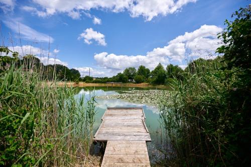 un muelle de madera en medio de un lago en Glamping Dordogne, en Douville