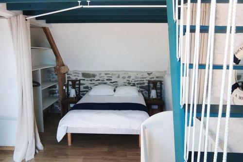 een slaapkamer met een bed met een blauwe en witte baldakijn bij Gîte Le Cabestan à la mer Lingreville in Lingreville