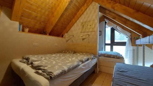 什平德萊魯夫姆林的住宿－Apartmán Zvon 302，一间设有一张床铺的卧室,位于一个拥有木制天花板的房间