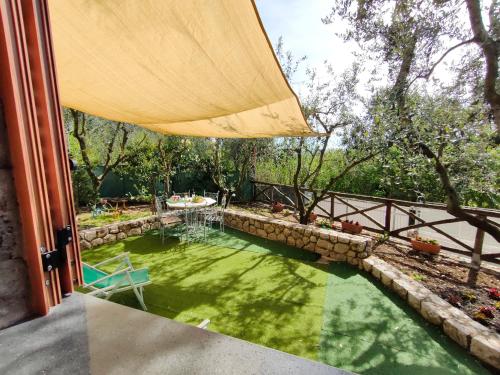 a pool of water with a table and an umbrella at Cynara holiday house in Massa Lubrense