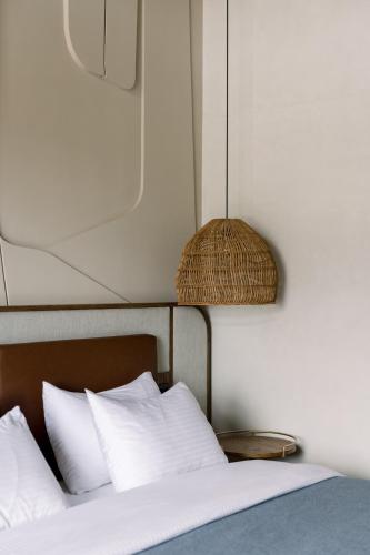 a bed with white pillows and a lamp next to it at Forest 1961 Boutique Hotel & Restaurant in Vanadzor
