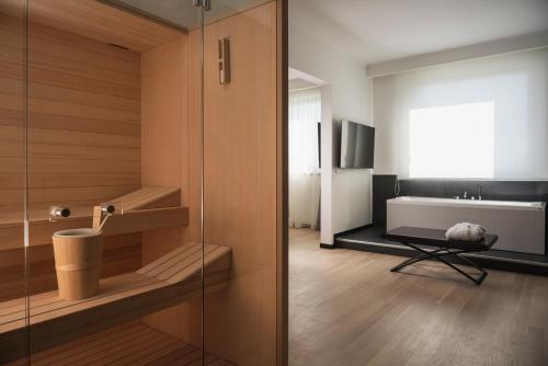 a bathroom with a glass door and a bath tub at Mitico Hotel & Natural Spa in Bologna