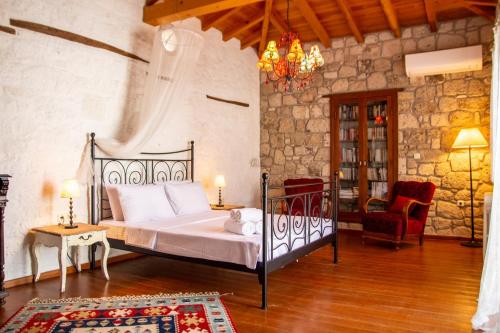 1 dormitorio con 1 cama grande y 1 silla en Marvelous Stonehouse With Backyard and Fireplace in Alacati Cesme, en Alacati