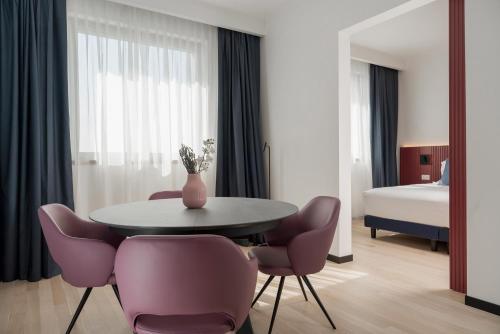 Zimmer mit einem Tisch, Stühlen und einem Bett in der Unterkunft Mitico Hotel & Natural Spa in Bologna