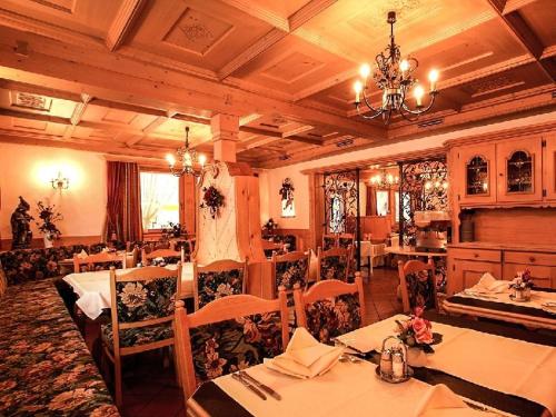 a restaurant with tables and chairs and a chandelier at Tirolerhof in Serfaus