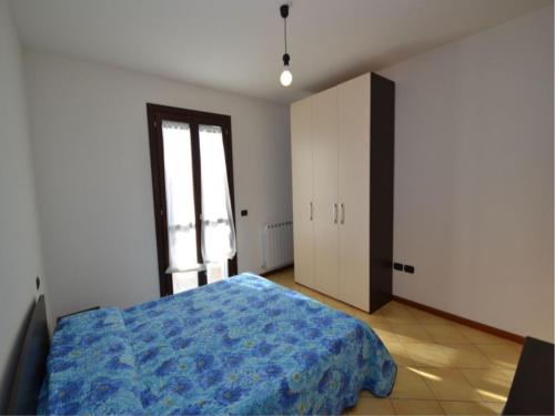 a bedroom with a blue bed and a window at Spacious apartment close to the beach - Beahost in Rosolina Mare