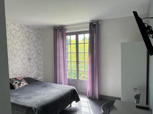 sypialnia z łóżkiem i oknem z fioletowymi zasłonami w obiekcie Le Chambellan w mieście Coux-et-Bigaroque