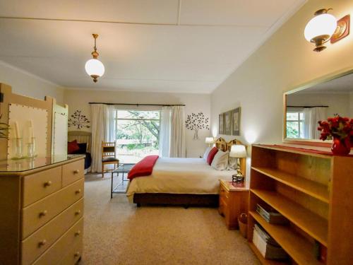 a bedroom with a bed and a large window at Rooiland Clarens in Clarens