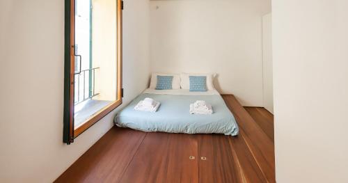 Cama pequeña en habitación con ventana en Welcomely - Cavour 47 en Alghero