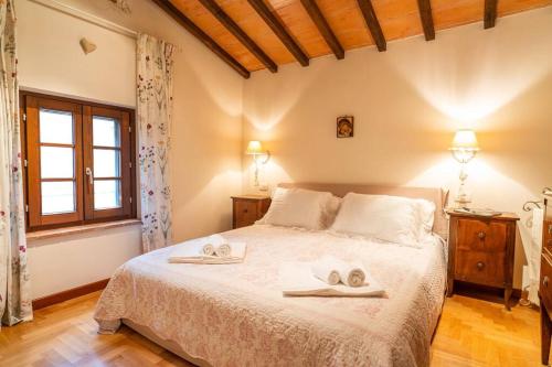 a bedroom with a large bed with towels on it at Iesa - Relax nella campagna di Siena in Lama