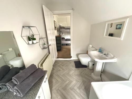 a white bathroom with a sink and a toilet at George Street Beverley in Beverley