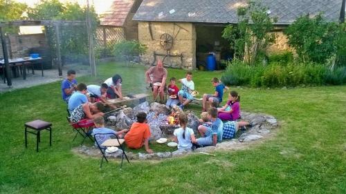 a group of children sitting around a fire in a yard at Bike Stop Duna in Dunaszentmiklós