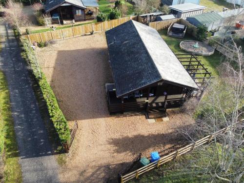 een uitzicht op een schuur met een metalen dak bij Cheerful 3-bedroom cabin with hot tub in Kings Lynn