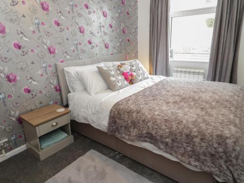 ein Schlafzimmer mit einem Bett mit einem Teddybär drauf in der Unterkunft 50A Lloyd Street West in Llandudno