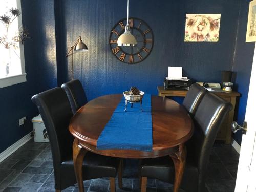 een eetkamer met een houten tafel en zwarte stoelen bij Minton cottage in Leadhills