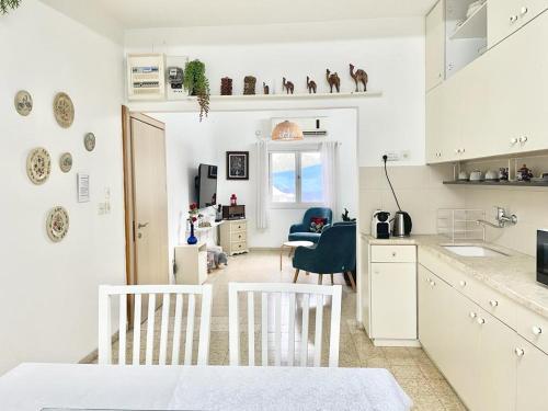 a kitchen with white cabinets and a table and chairs at Beautiful Apartment in Kibbutz Yifat in Yif‘at