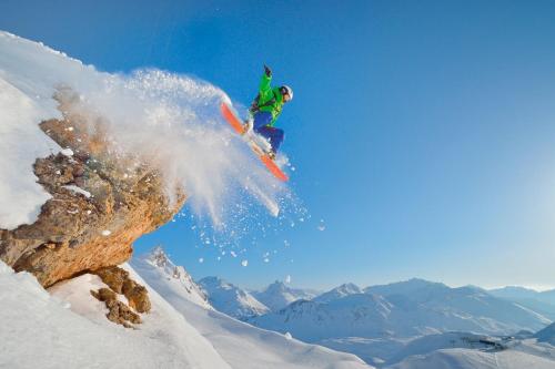 a man flying through the air while riding a snowboard at Hotel Arlmont 4 Stern Superior in Sankt Anton am Arlberg