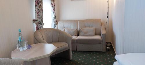 a room with a chair and a chair and a table at Hotel Meereswelle - Anno 1875 in Ahlbeck