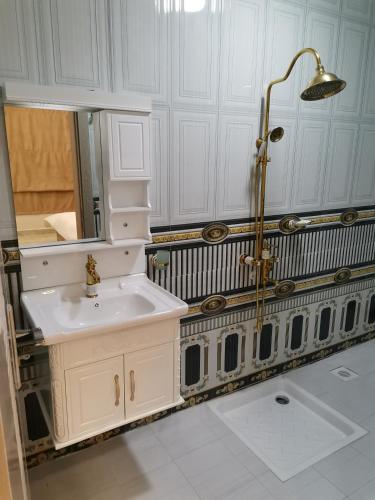 a white bathroom with a sink and a shower at مارينا للغرف الفندقية in Sohar