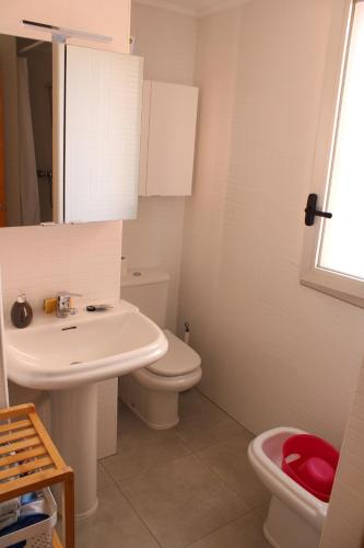 uma casa de banho com um lavatório branco e um WC. em Apartamento acogedor con piscina en Santa Margarita em Roses