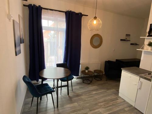een woonkamer met een tafel en stoelen en een raam bij Apartments Osterstraße in Norden