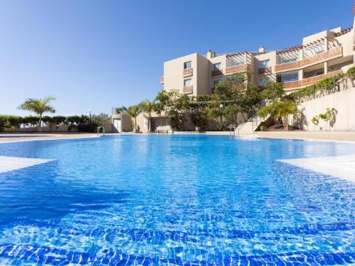 a large swimming pool in front of a building at Apartamento VISTA ROJA - LA TEJITA in El Médano