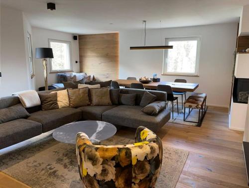 ein Wohnzimmer mit einem Sofa und einem Tisch in der Unterkunft Luxury Mountain Apartment with Private Sauna and Underground Parking in St. Moritz