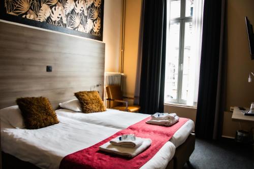 a hotel room with two beds with towels on them at Hotel Industrie in Leuven