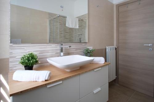 ein Badezimmer mit einem weißen Waschbecken auf einer Holztheke in der Unterkunft Appartamento Peppino in San Salvo